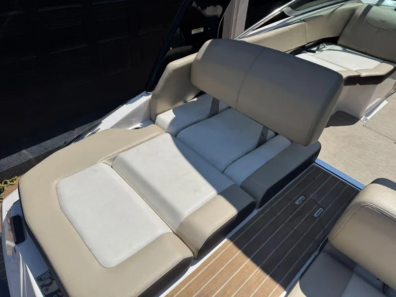Slide: The Image of 2014 Regal 2300 Bowrider boat interior with beige seating and wood-style flooring. - 12