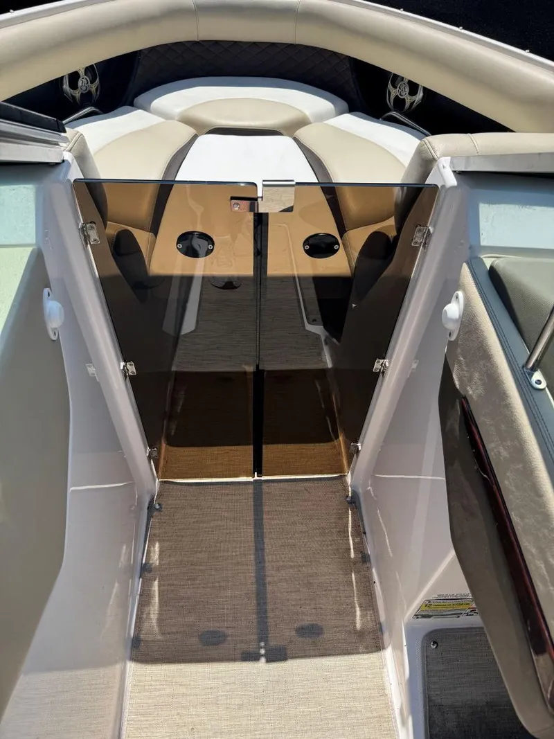 Slide: The Image of 2014 Regal 2300 Bowrider interior with open glass doors and cushioned seating. - 21
