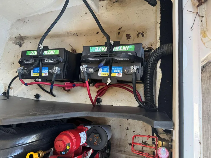 Slide: The Image of 2014 Regal 2300 Bowrider boat battery compartment with dual batteries and wiring. - 25