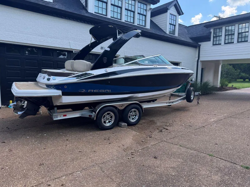 Slide: The Image of 2014 Regal 2300 Bowrider boat on trailer, parked in driveway near house. - 3
