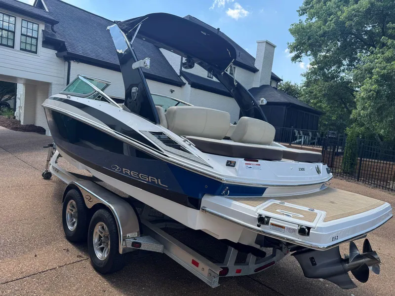 Slide: The Image of 2014 Regal 2300 Bowrider boat on trailer, parked in driveway near house. - 6