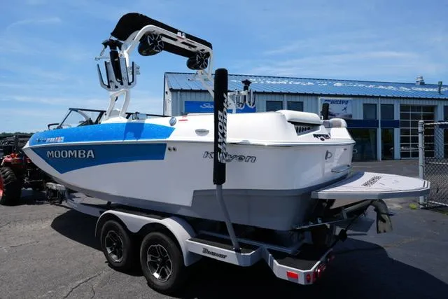 Slide: The Image of 2023 Moomba Kaiyen boat on trailer, blue and white, parked outside dealership. - 5