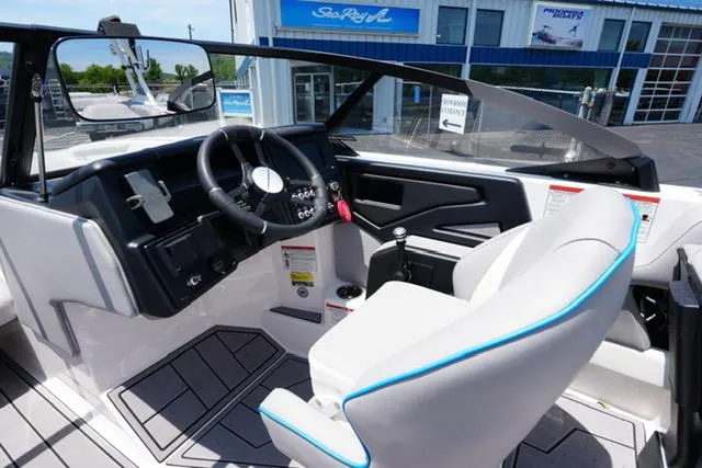 Slide: The Image of 2023 Moomba Kaiyen boat interior with steering wheel and seating, displayed at a dealership. - 9