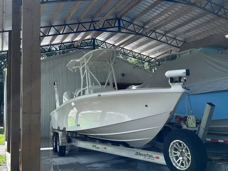 Slide: The Image of 2023 SeaVee 270Z boat on trailer under a metal roofed shelter. - 14