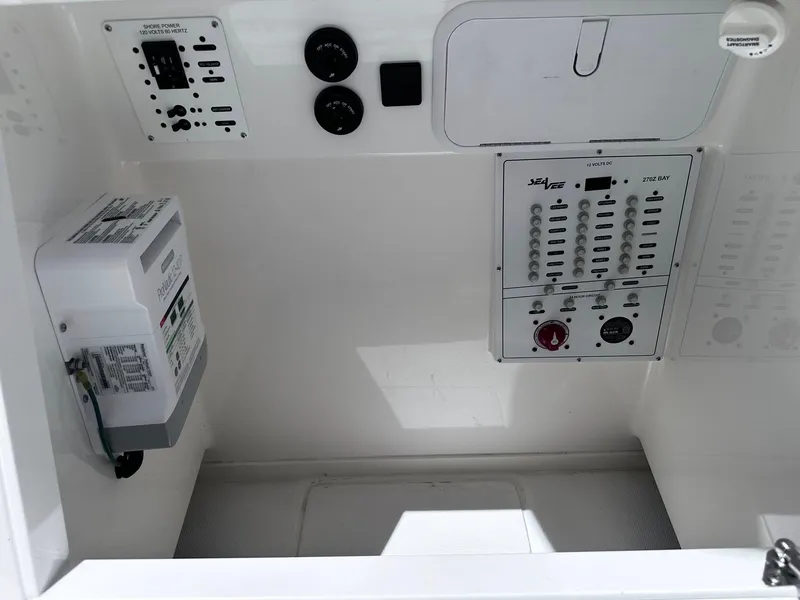 Slide: The Image of 2023 SeaVee 270Z control panel with switches and gauges in a white compartment. - 19