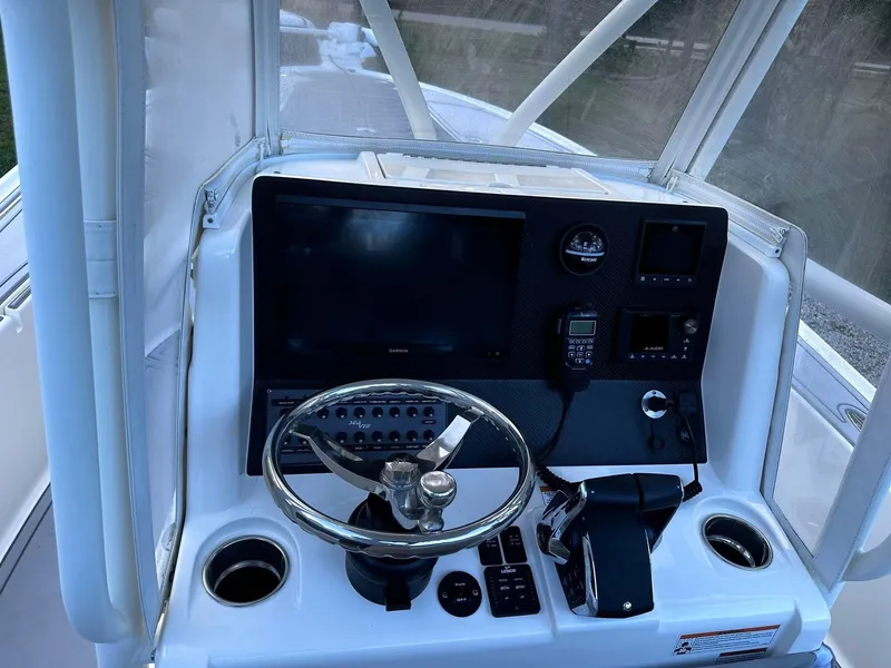 Slide: The Image of 2023 SeaVee 270Z helm with steering wheel, controls, and navigation equipment. - 2