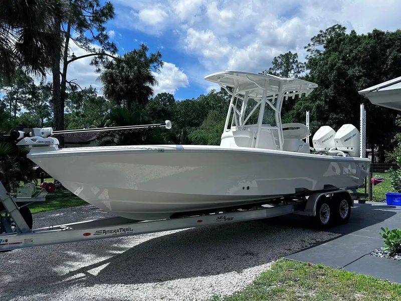 Slide: The Image of 2023 SeaVee 270Z boat on trailer, parked outdoors under a partly cloudy sky. - 22