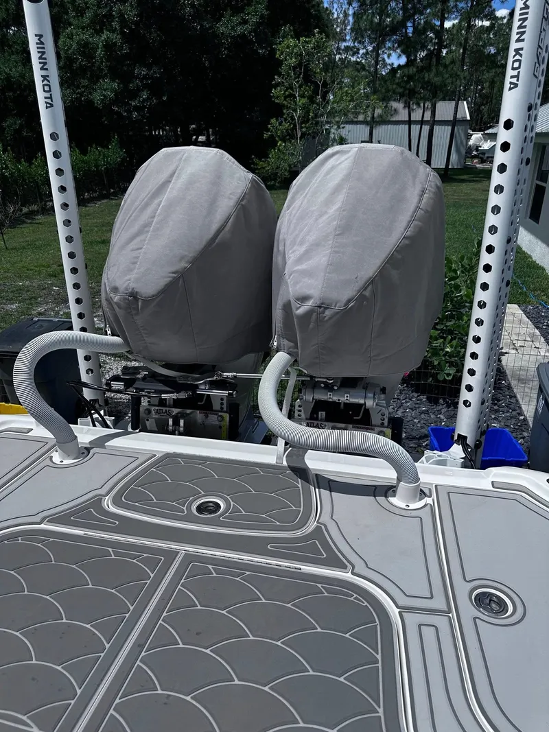 Slide: The Image of 2023 SeaVee 270Z boat with covered engines and Minn Kota poles in a backyard setting. - 23