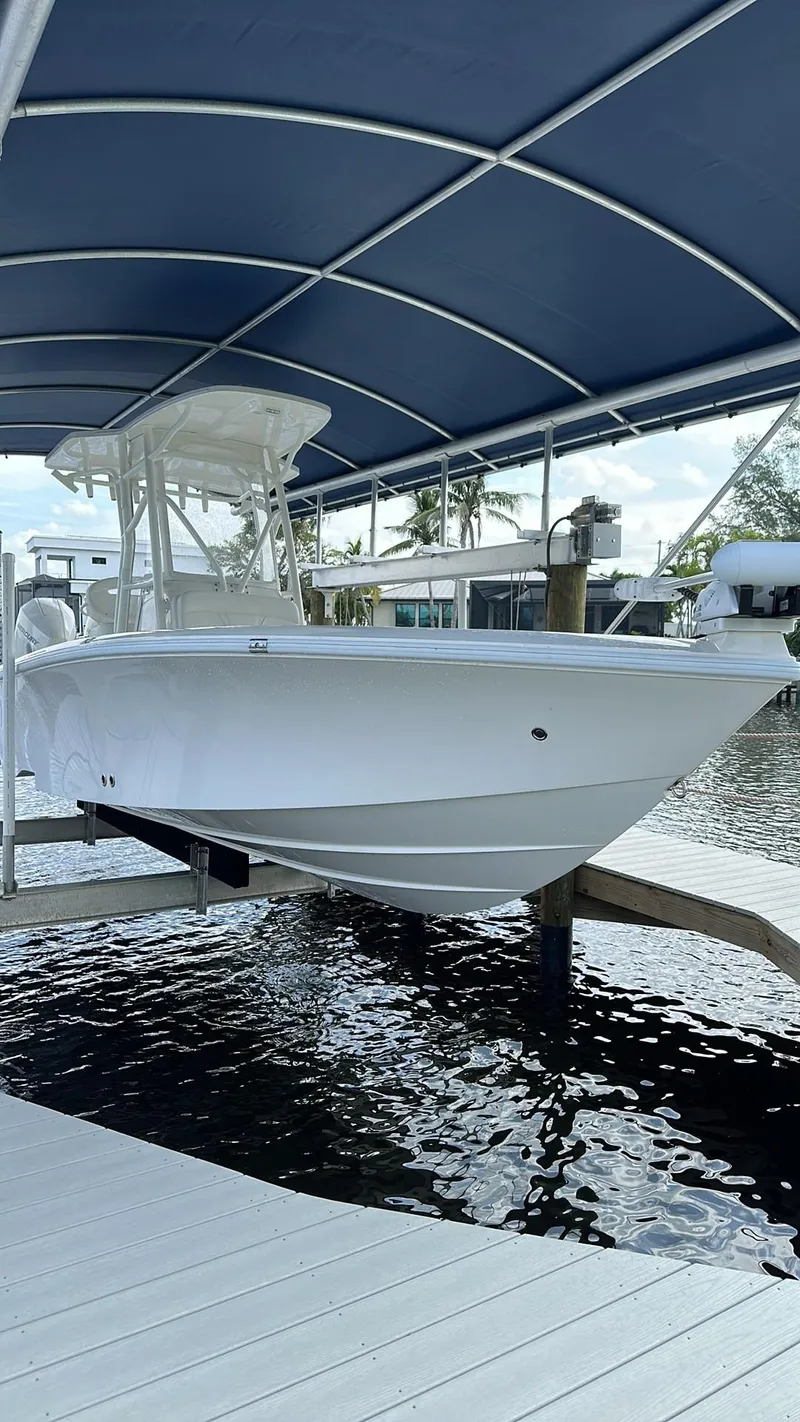 Slide: The Image of 2023 SeaVee 270Z boat docked under a blue canopy on a sunny day. - 24