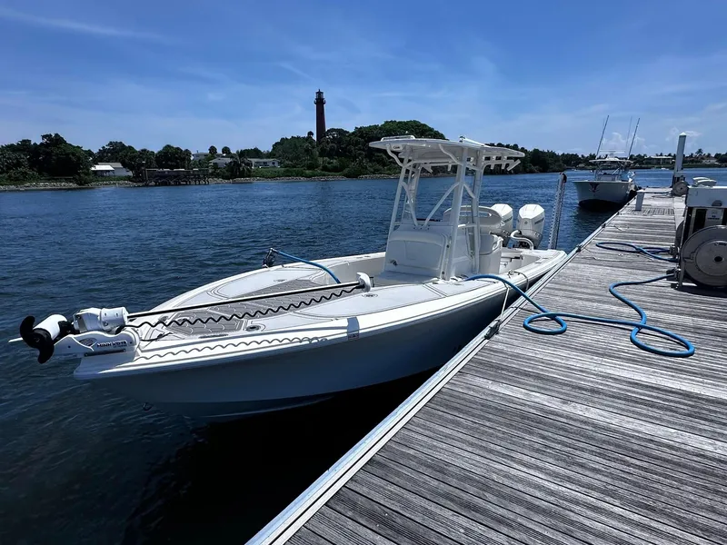 Slide: The Image of 2023 SeaVee 270Z boat docked by a scenic waterfront with a lighthouse in the background. - 25