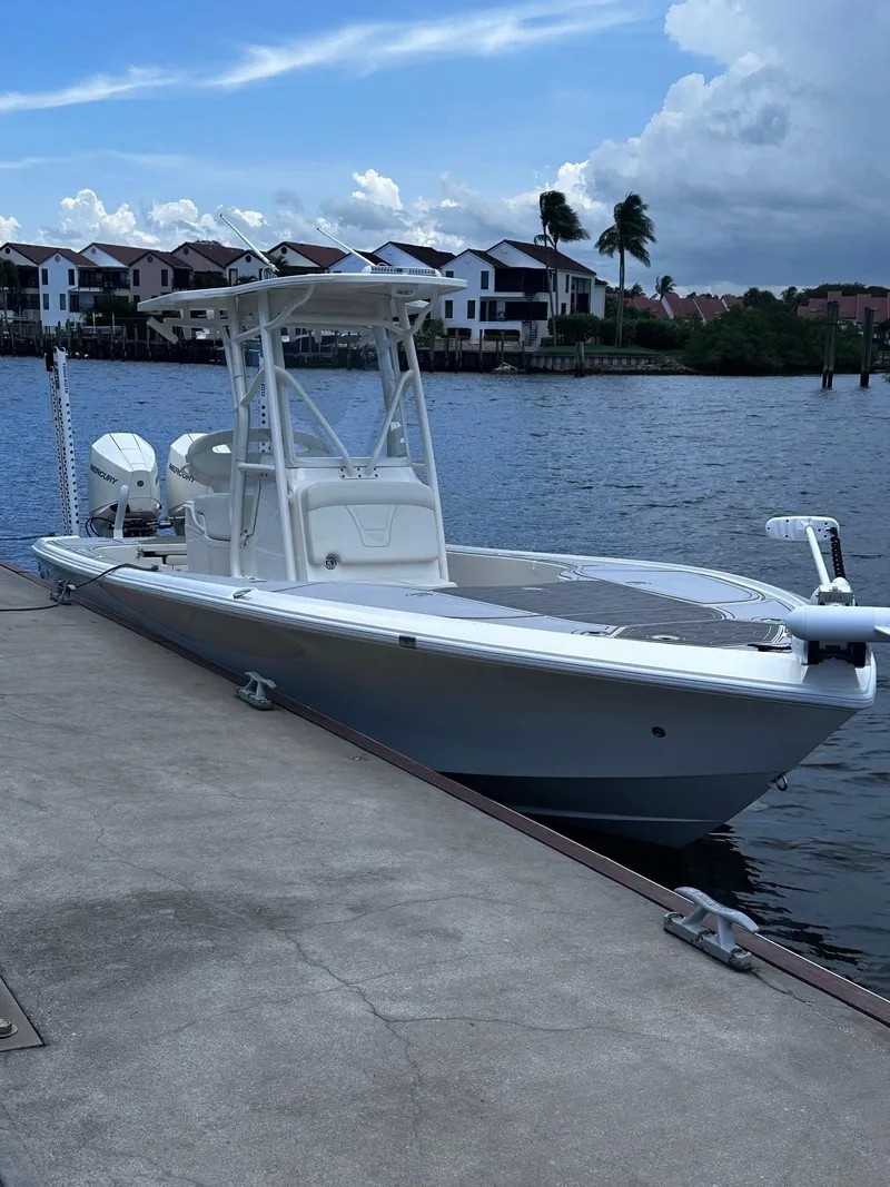 Slide: The Image of 2023 SeaVee 270Z boat docked by waterfront homes under a cloudy sky. - 9