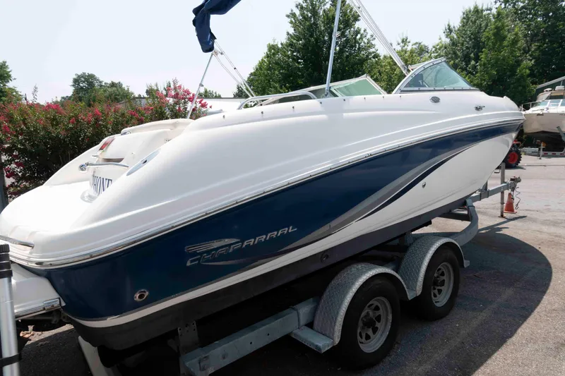 Slide: The Image of 2004 Chaparral 230 SSi boat on trailer, white and blue, parked outdoors. - 3