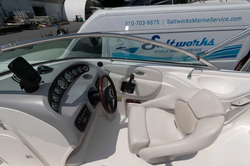 Slide: The Image of 2004 Chaparral 230 SSi boat cockpit with steering wheel and gauges, near Saltworks Marine Service van. - 7