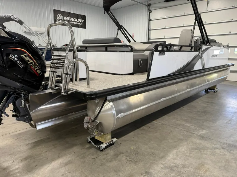 Slide: The Image of 2025 Avalon LSZ Versatile Rear Lounger pontoon boat in showroom, featuring Mercury engine. - 6