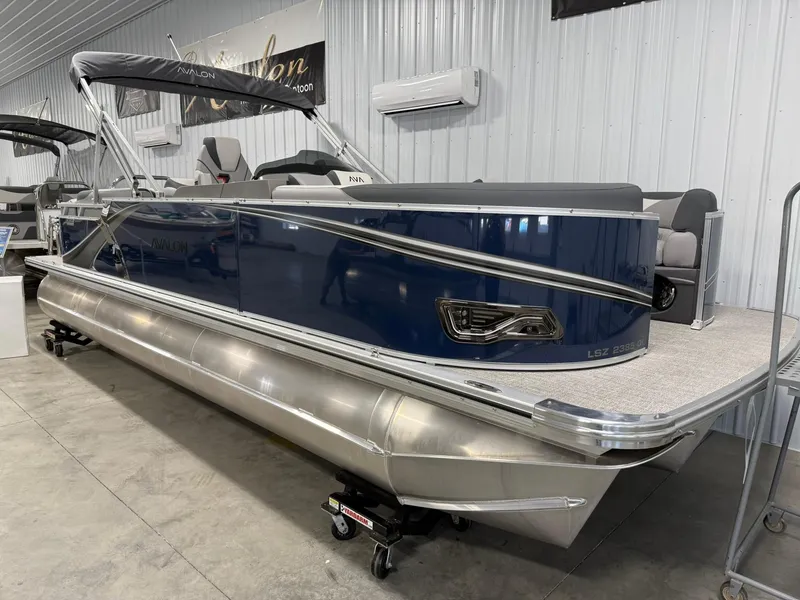 Slide: The Image of 2025 Avalon LSZ Quad Lounger pontoon boat in showroom, featuring sleek design and modern amenities. - 17