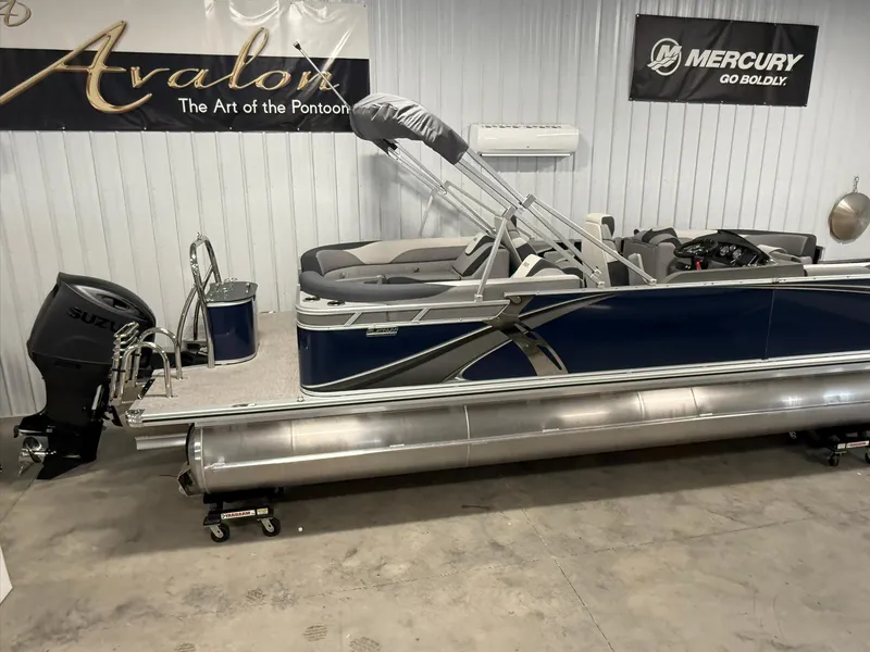 Slide: The Image of 2025 Avalon LSZ Quad Lounger pontoon boat in showroom with Suzuki outboard motor. - 3