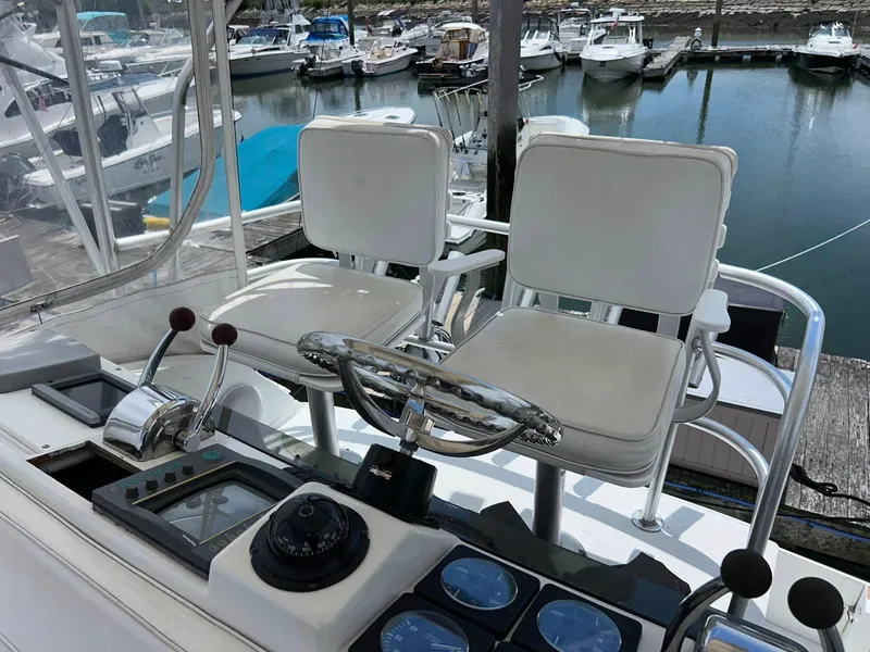 Slide: The Image of 1996 Luhrs 32 Convertible boat helm with dual seats and control panel at marina. - 10