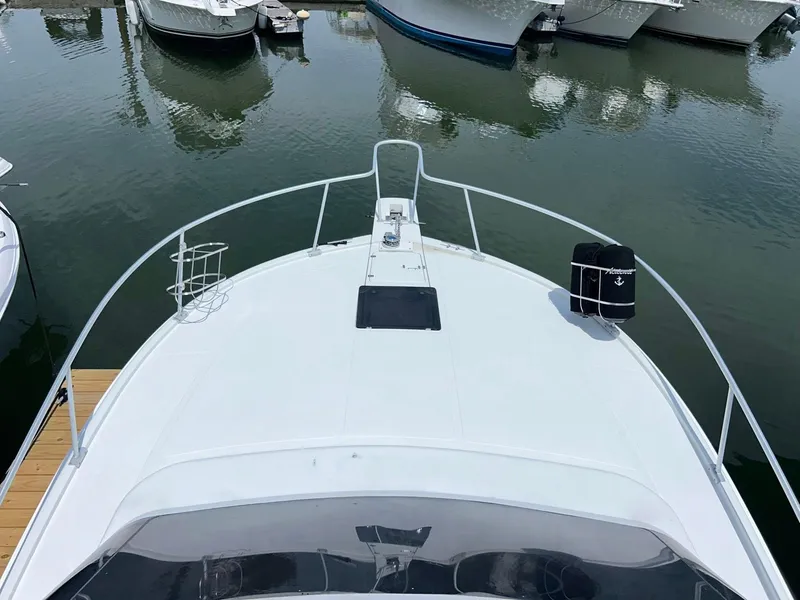 Slide: The Image of 1996 Luhrs 32 Convertible boat docked in a marina, view from the bow. - 12