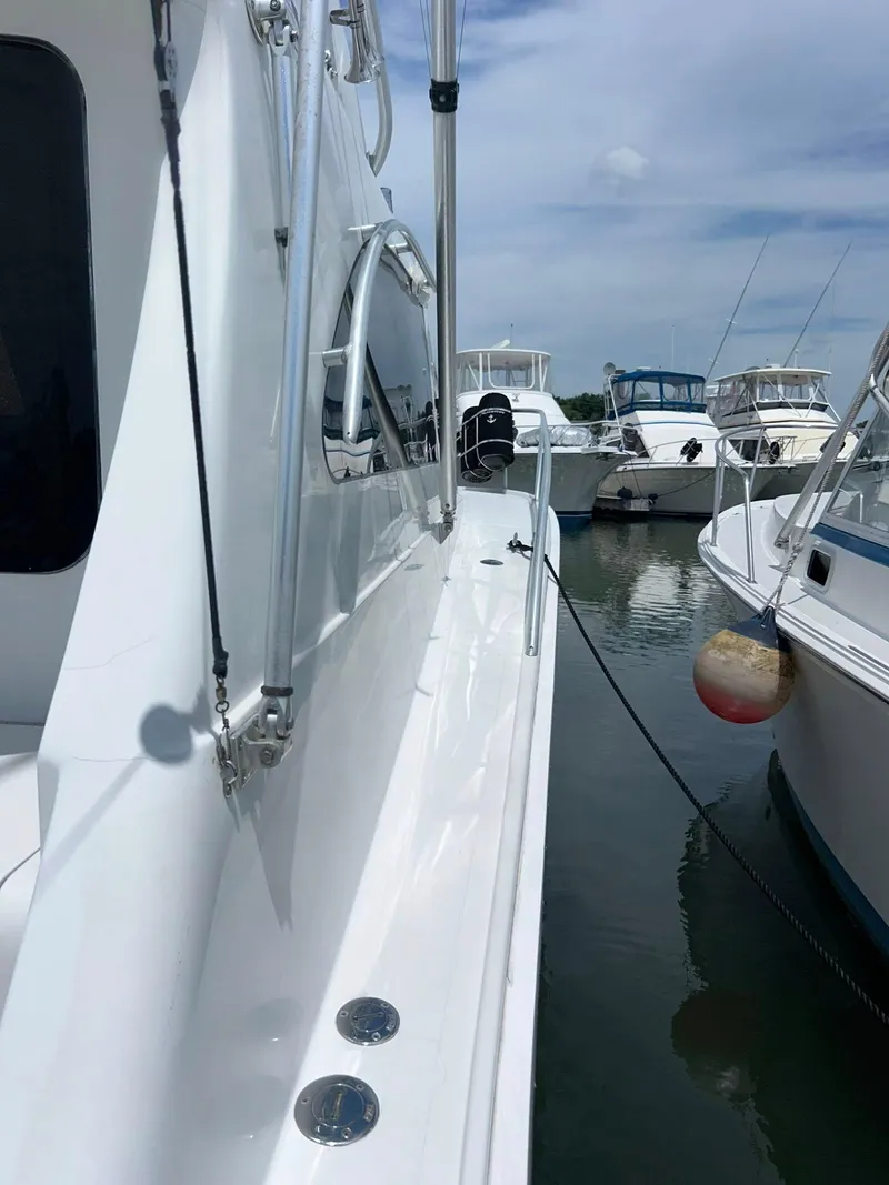 Slide: The Image of 1996 Luhrs 32 Convertible yacht docked at marina, side view with clear sky. - 13