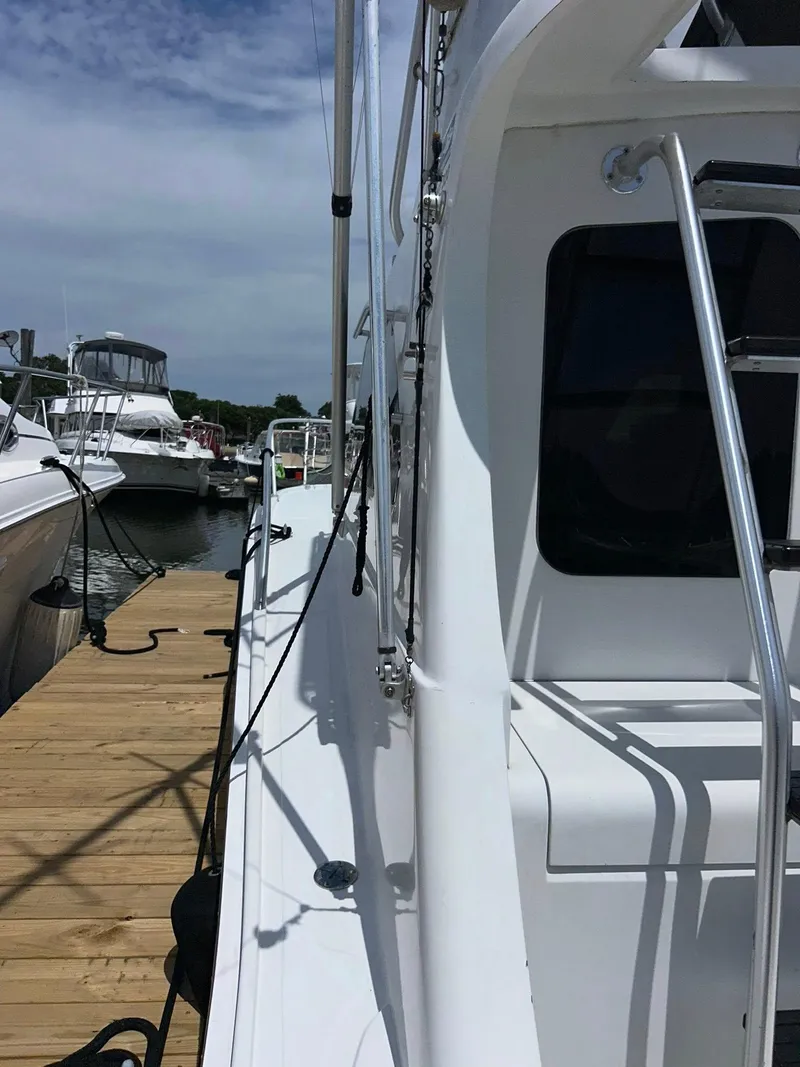 Slide: The Image of 1996 Luhrs 32 Convertible yacht docked at marina under clear sky. - 14