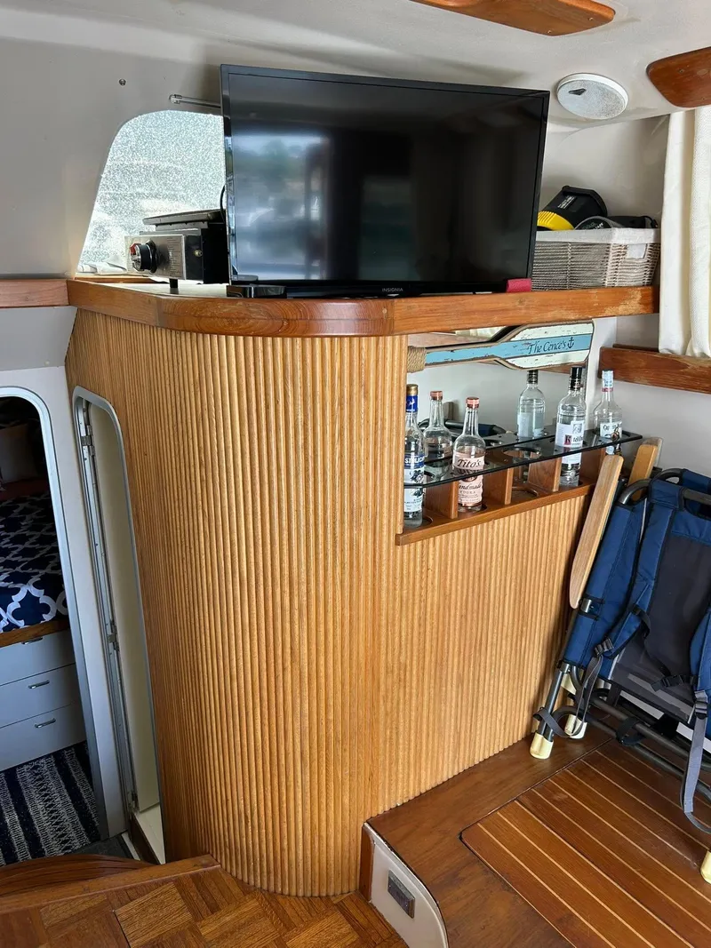 Slide: The Image of 1996 Luhrs 32 Convertible interior with TV, bar, and wooden paneling. - 19