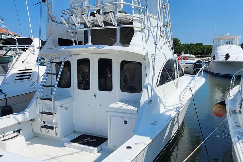 Slide: The Image of 1996 Luhrs 32 Convertible yacht docked in a marina, rear view. - 2