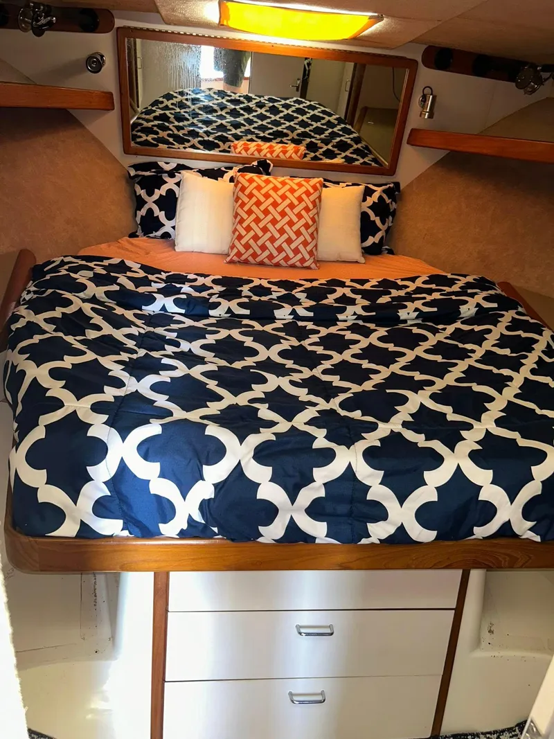 Slide: The Image of Cozy cabin interior of 1996 Luhrs 32 Convertible with patterned bedding and storage drawers. - 21