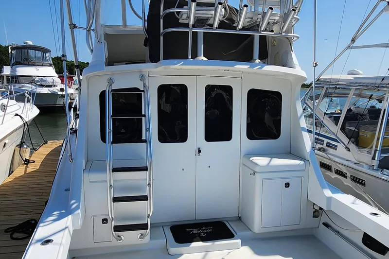 Slide: The Image of 1996 Luhrs 32 Convertible boat with ladder and cabin doors at a marina. - 3