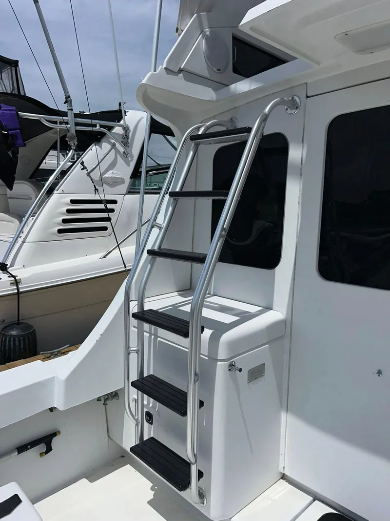 Slide: The Image of 1996 Luhrs 32 Convertible boat ladder and deck area, showcasing sleek design and functionality. - 8