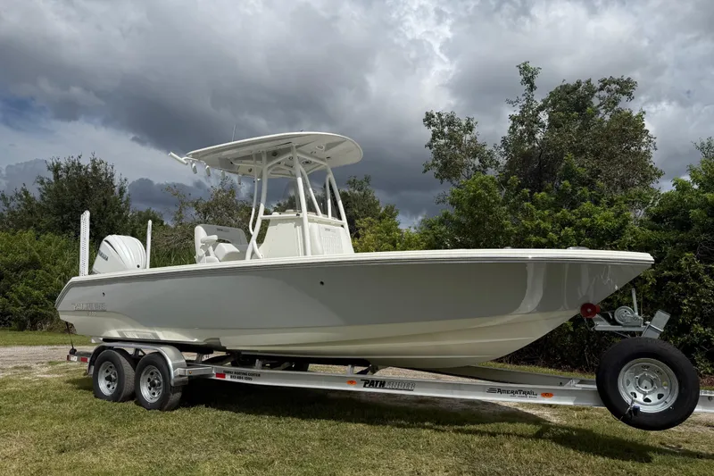 Slide: The Image of 2025 Pathfinder 2400 TRS boat on trailer, parked on grass under cloudy sky. - 10
