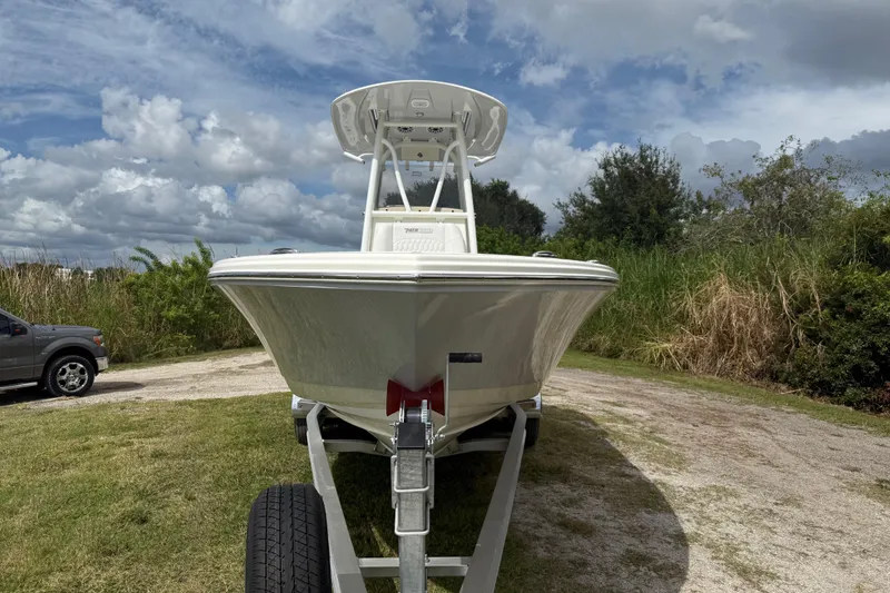 Slide: The Image of 2025 Pathfinder 2400 TRS boat on trailer, parked outdoors under cloudy sky. - 11