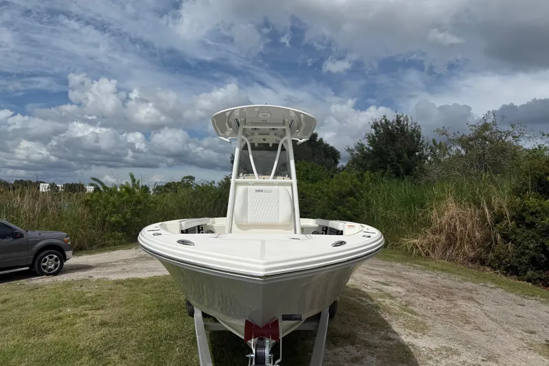 Slide: The Image of 2025 Pathfinder 2400 TRS boat on trailer, parked outdoors under cloudy sky. - 12