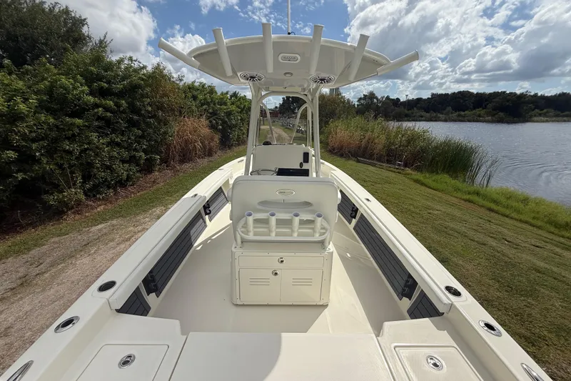 Slide: The Image of 2025 Pathfinder 2400 TRS boat on grassy lakeside, clear sky background. - 14