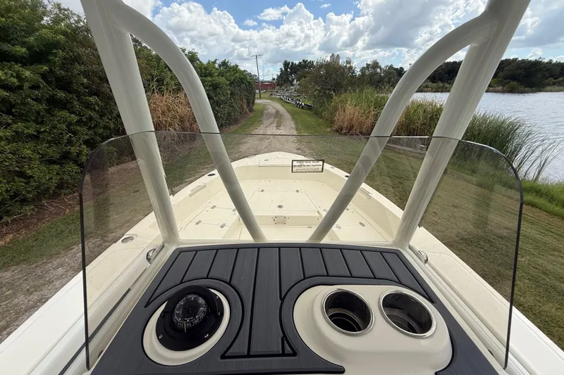 Slide: The Image of 2025 Pathfinder 2400 TRS boat interior with compass, cup holders, and scenic waterway view. - 17