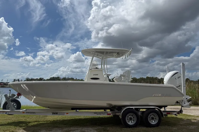 Slide: The Image of 2025 Pathfinder 2400 TRS boat on trailer under cloudy sky. - 2