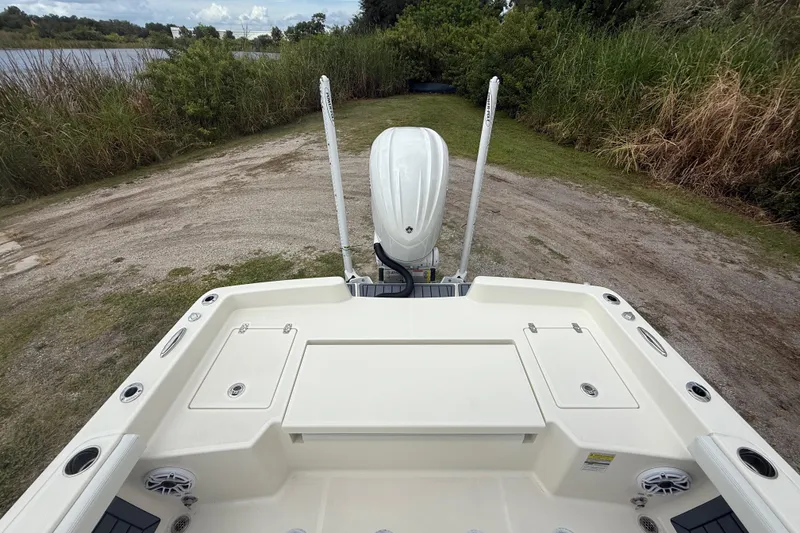 Slide: The Image of 2025 Pathfinder 2400 TRS boat at a lakeside launch area, rear view. - 24