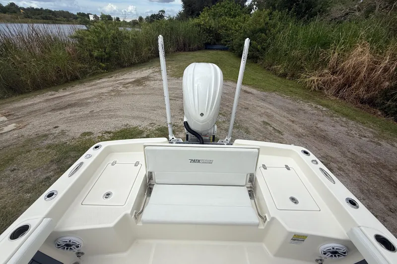 Slide: The Image of 2025 Pathfinder 2400 TRS boat at a lakeside launch area, featuring a clean deck design. - 25