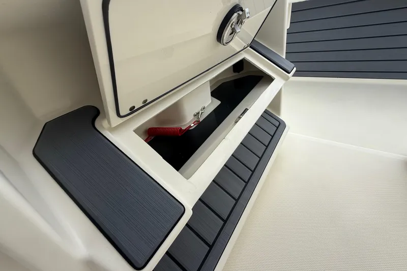 Slide: The Image of Pathfinder 2400 TRS 2025 boat storage compartment with black trim and latch. - 38