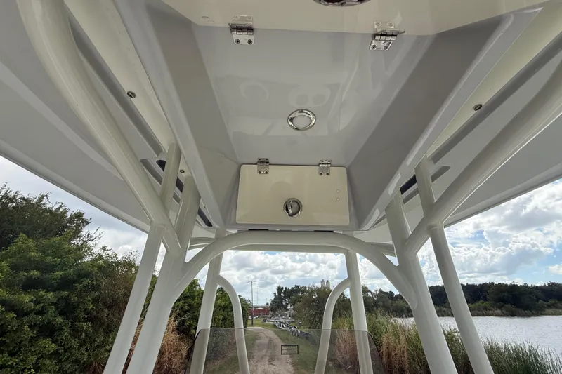 Slide: The Image of 2025 Pathfinder 2400 TRS boat interior view with overhead storage and scenic background. - 39