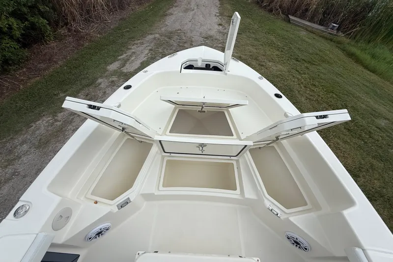 Slide: The Image of 2025 Pathfinder 2400 TRS boat with open storage compartments on a grassy path. - 45