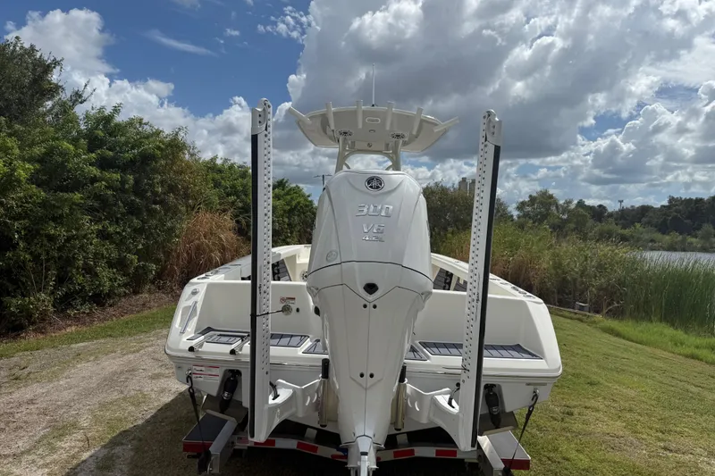Slide: The Image of 2025 Pathfinder 2400 TRS boat with Yamaha 300 V6 engine, parked on grass under cloudy sky. - 5