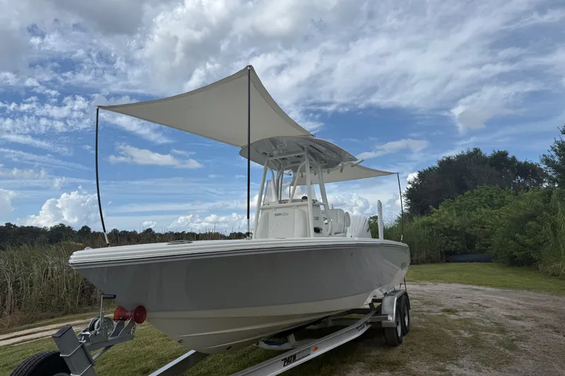 Slide: The Image of 2025 Pathfinder 2400 TRS boat on trailer with canopy, set against a cloudy sky. - 53