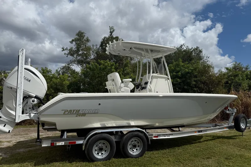 Slide: The Image of 2025 Pathfinder 2400 TRS boat on trailer, side view, under cloudy sky. - 8