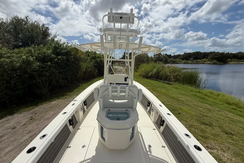 Slide: The Image of 2025 Pathfinder 2400 Open boat on grassy shore by a lake under cloudy sky. - 13