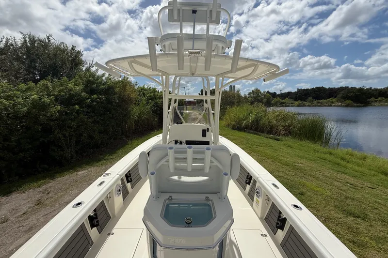 Slide: The Image of 2025 Pathfinder 2400 Open boat on grassy shore, under a partly cloudy sky. - 14