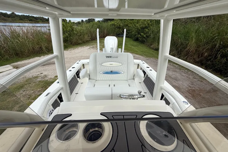 Slide: The Image of 2025 Pathfinder 2400 Open boat interior with seating and console, near a lakeside. - 25