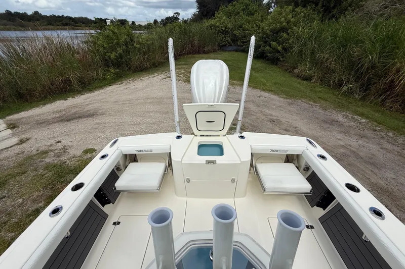 Slide: The Image of 2025 Pathfinder 2400 Open boat interior with seating and storage, near a scenic waterway. - 27