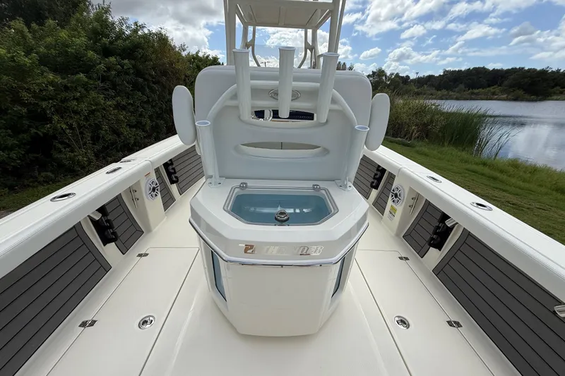 Slide: The Image of 2025 Pathfinder 2400 Open boat interior with seating and storage, near a scenic lake. - 30