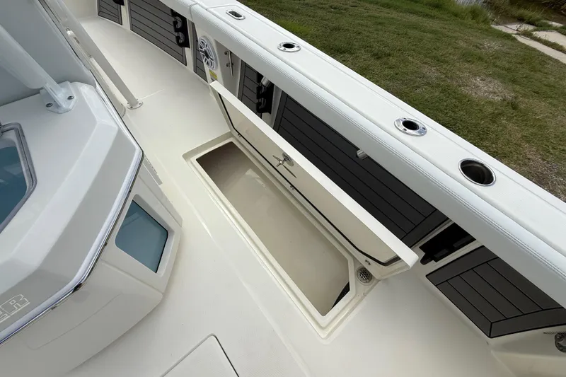 Slide: The Image of 2025 Pathfinder 2400 Open boat deck with storage compartment and rod holders. - 35