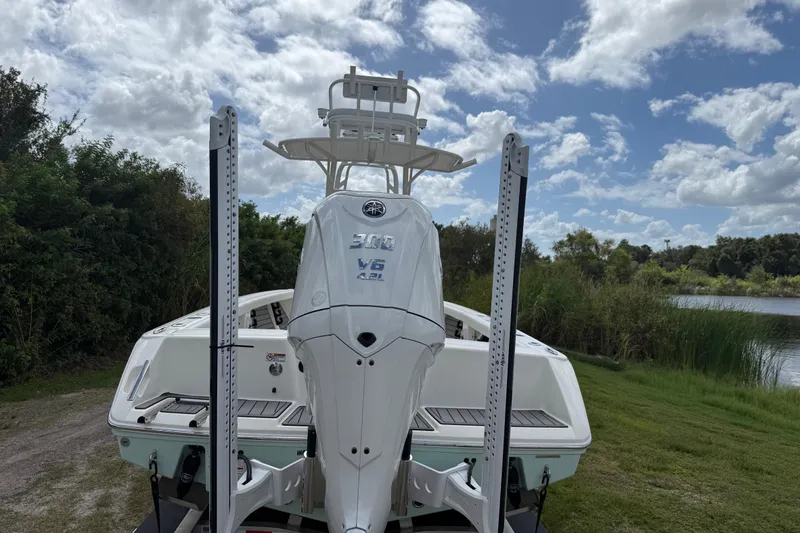 Slide: The Image of 2025 Pathfinder 2400 Open boat with powerful V6 engine, parked near lush greenery and blue sky. - 4